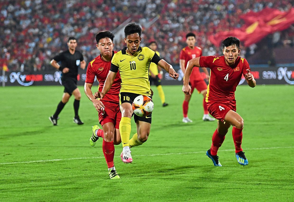 PHU THO, 19 Mei -- Pemain Malaysia, Luqman Hakim Shamsudin (tengah) mengawal bola ketika menentang pasukan Vietnam pada saingan Sukan SEA 2021 di Stadium Viet Tri malam ini.Perlawanan dilanjutkan ke masa tambahan selepas terikat 0-0.-- fotoBERNAMA (2022) HAK CIPTA TERPELIHARA
