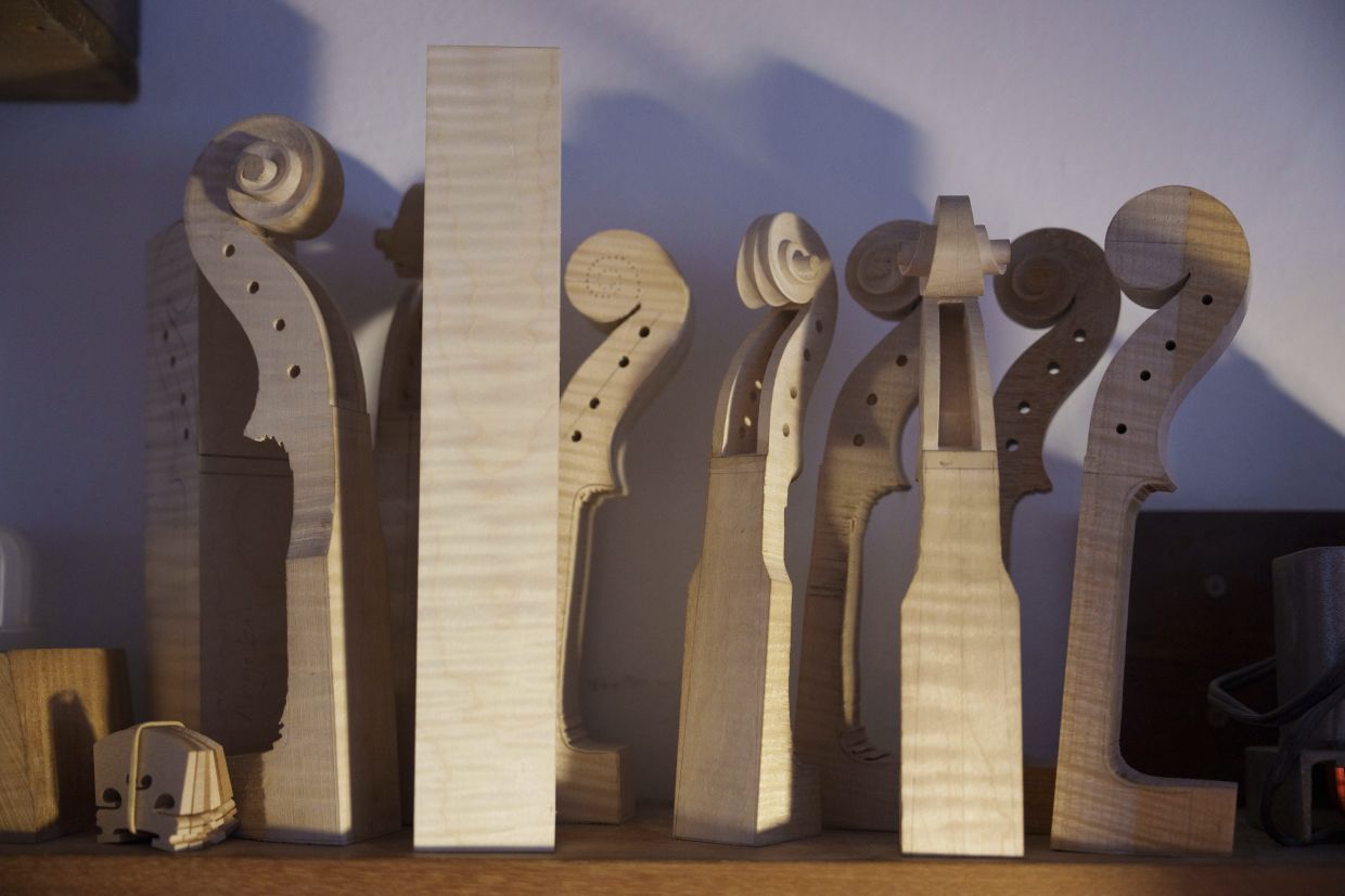 Violin scrolls sit on the workstation of Malaysian luthier Tan Chin Sang Violin on the outskirt of Kuala Lumpur, Malaysia, Thursday, July 2, 2025. (AP Photo/Vincent Thian)