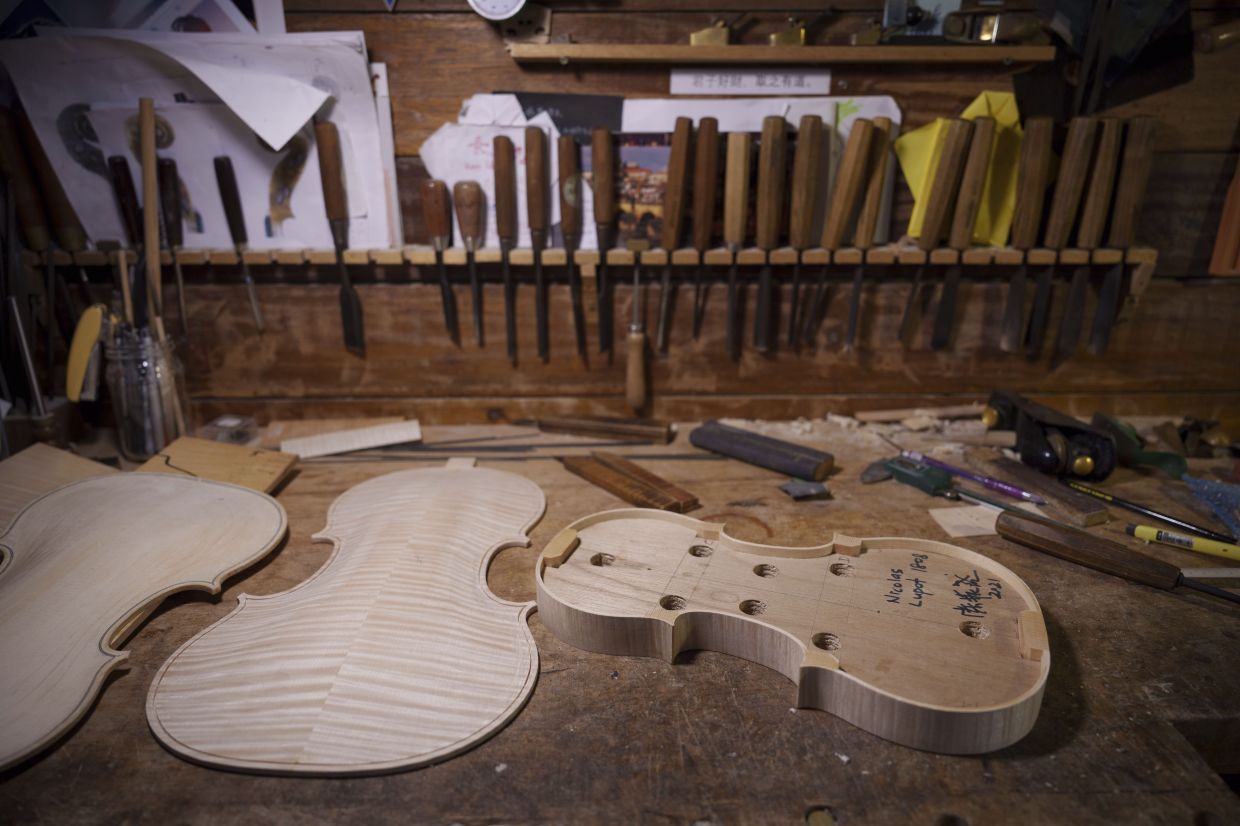 Hand crafted violin pieces lay on the crafting table of Malaysian luthier Tan Chin Sang ons the outskirt of Kuala Lumpur, Malaysia, Thursday, July 2, 2025. (AP Photo/Vincent Thian)