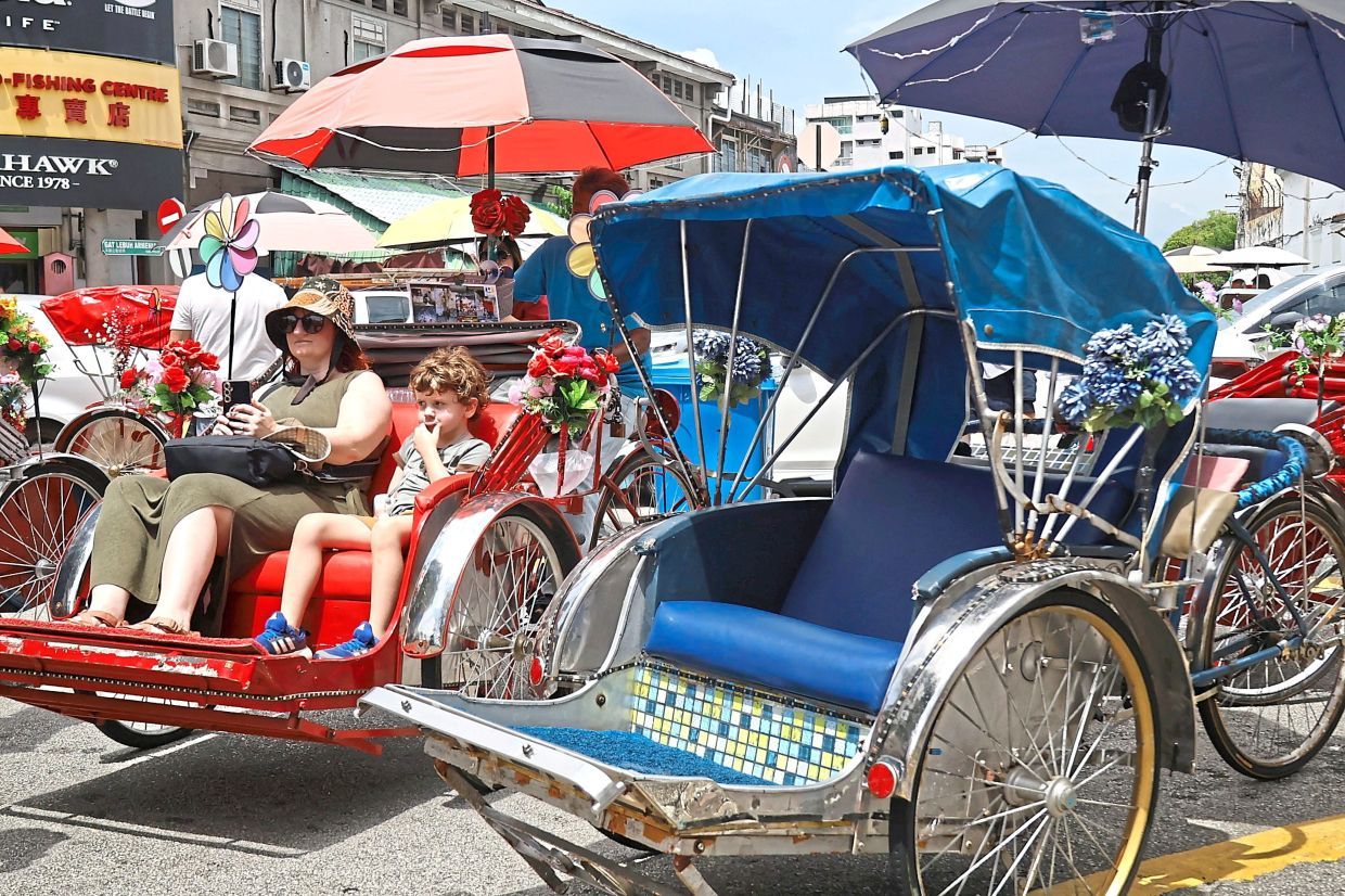 Tourist enjoying their trishaw ride at Heritage area in George Town, Penang.( July 12, 2025 ) ¡ª CHAN BOON KAI/The Star