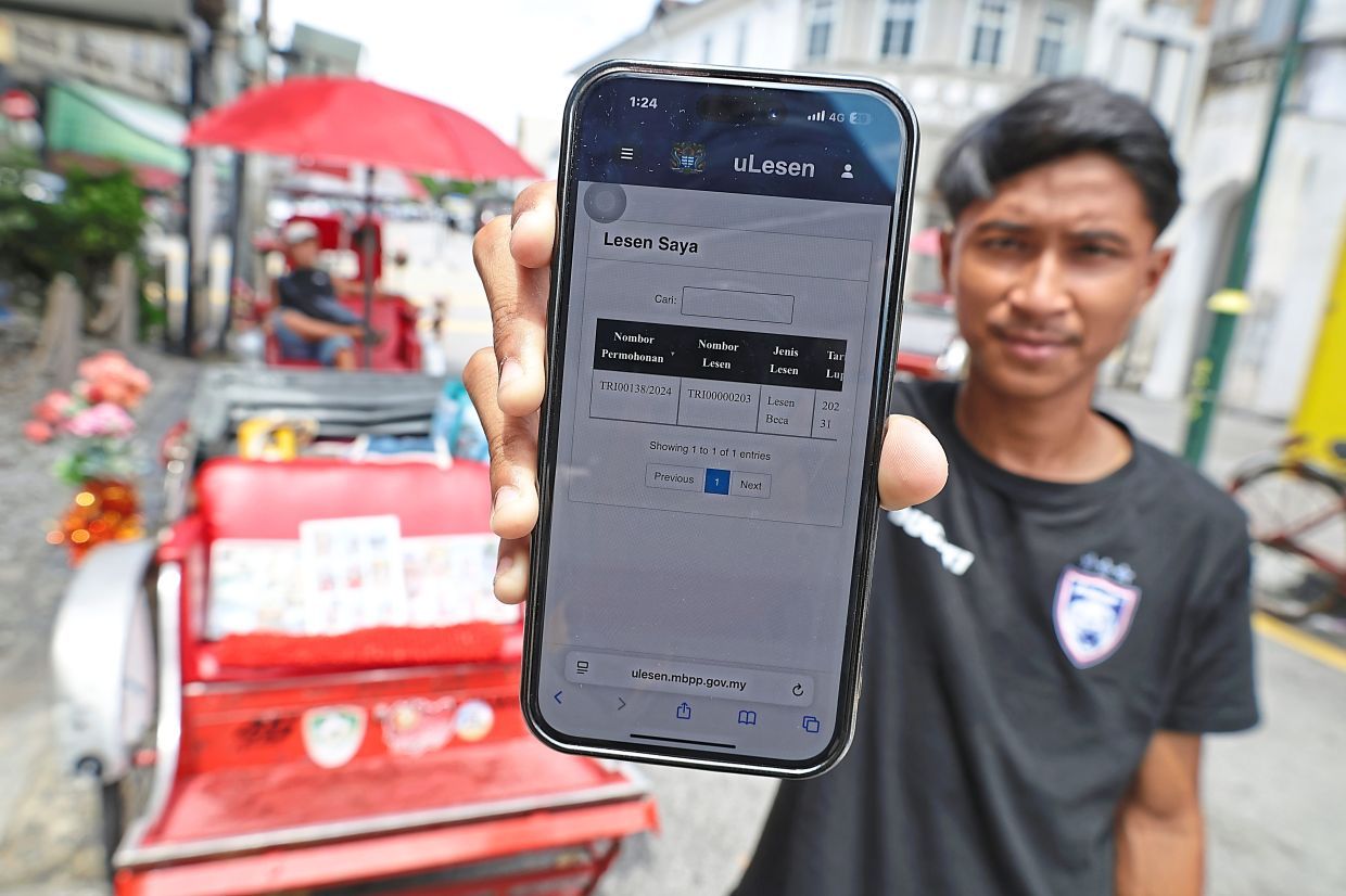 (BRIEF CAPTION): Mohd Ammar Hakimi, 23, showing his online trishaw licensing system, uLesen at Armenian Street in George Town, Penang.( JUNE 17, 2025)¡ªCHAN BOON KAI/The Star