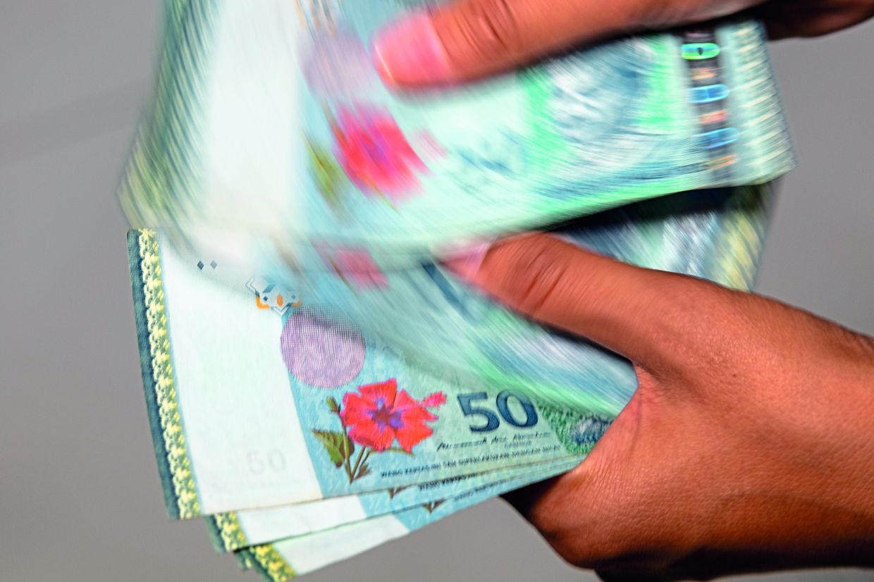 Gaining ground: A man counting ringgit notes. An analyst from a local think tank says Malaysians should gain on many fronts from a stronger currency.
