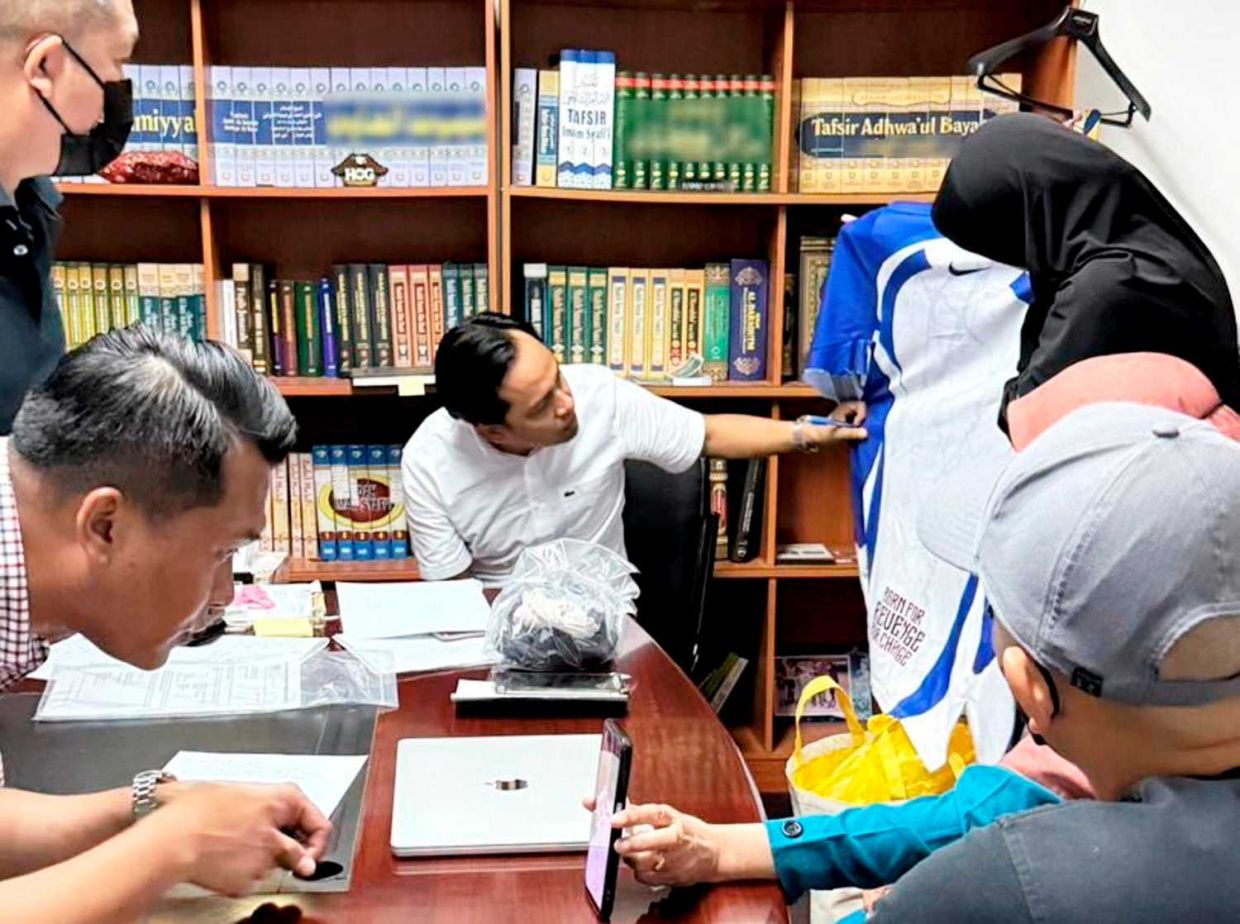 Lawyer Shahlan Jufri (seated) showing the clothes last used Zara Qairina that was not seized by the cops for their investigations.
