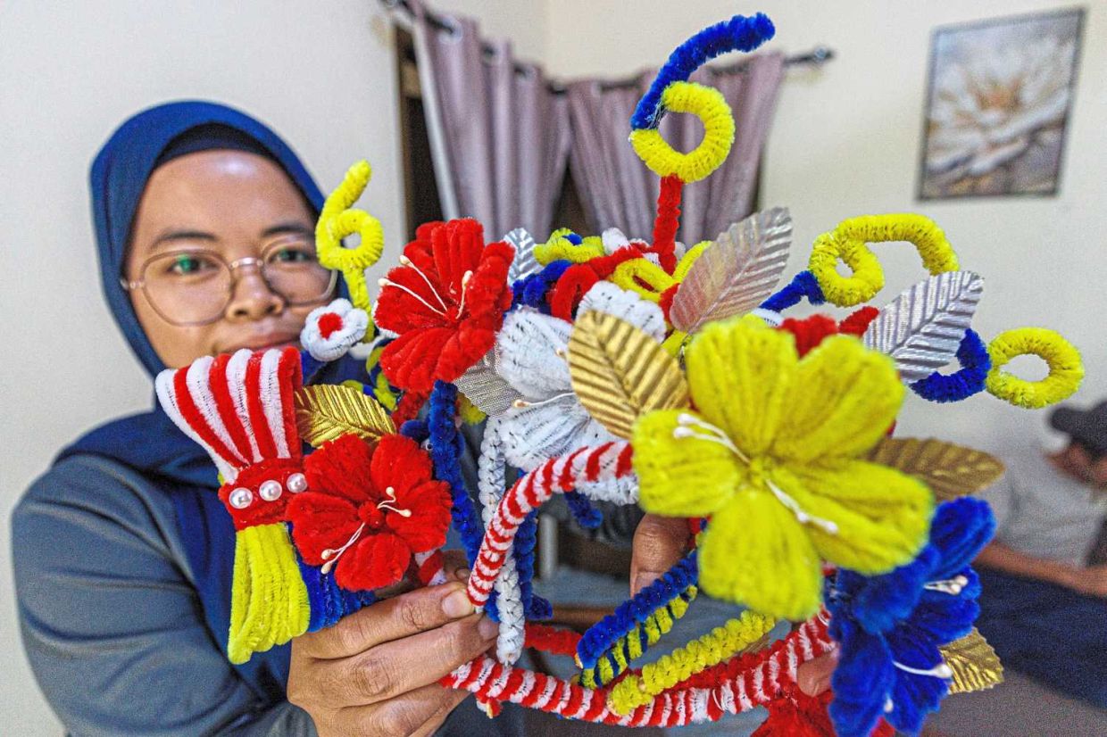 Aziefitri Morni showing her Merdeka-inspired headbands in the colours of the Jalur Gemilang. – ZULAZHAR SHEBLEE / The Star