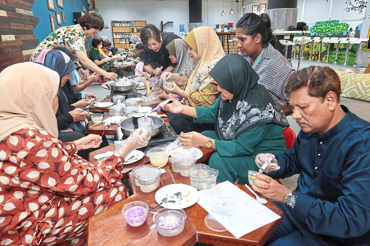 Zainol Abdul Rahman, 62 (right) showing the flower jelly cakes while Alice Lim, 53, giving instructions on how to make flower jelly cakes during a workshop organised by MBPP at the community centre in Bayan Baru.(August 30, 2025) —ZHAFARAN NASIB/The Star