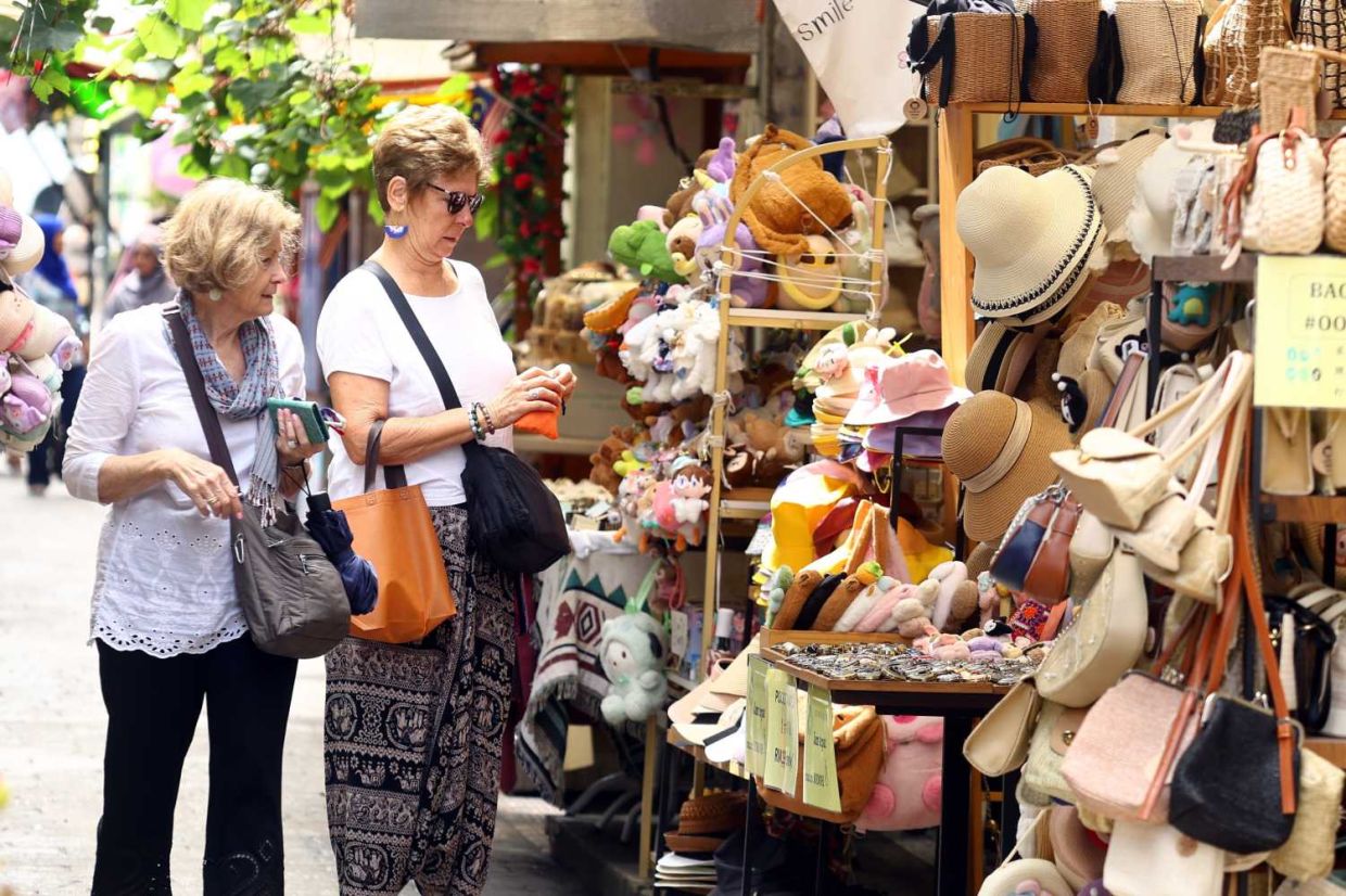 Foreign tourist enjoying the peaceful Ipoh atmosphere at Concubine Lane.(3rd September 2025)--RONNIE CHIN/The Star