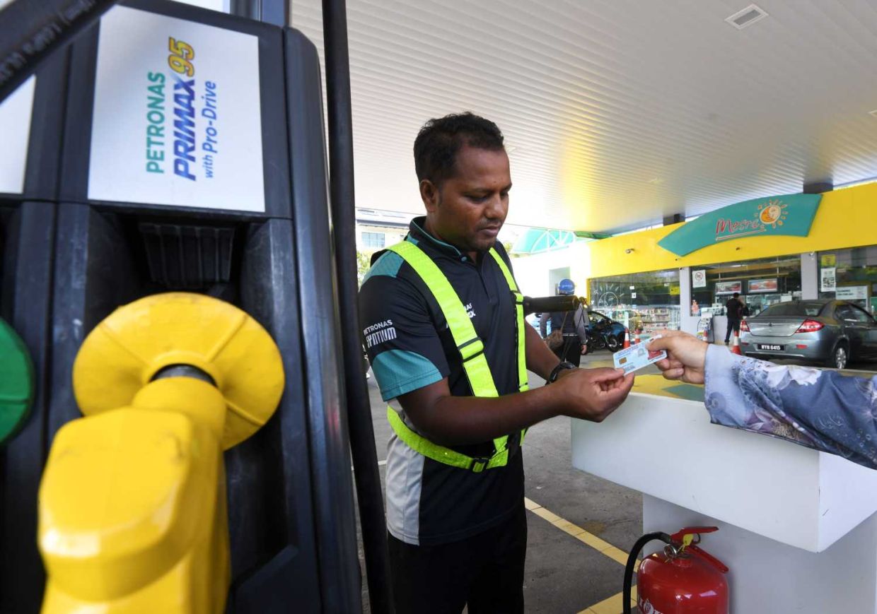 A petrol station staff checking IC at Petronas station in Bandar Kinrara.Photo for the story Mykad for the RON95 subsidary..—AZHAR MAHFOF/The Star