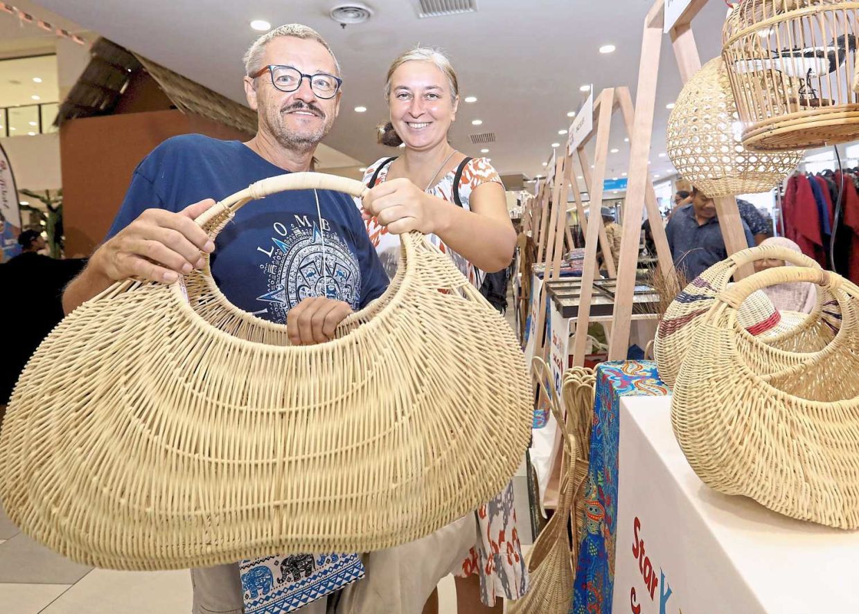 (From left) Michael Mick who originated from Germany and his wife Nataliia Smetanina who originated from Ukraine were drawn in by the carnival's setting as they stepped into Kuantan City Mall.