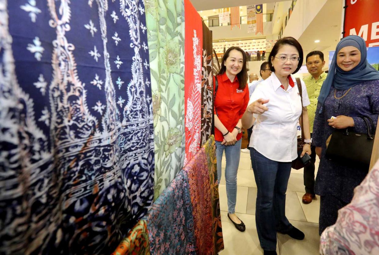 (From left) Star Media Group Berhad (SMG) Client Brand Marketing senior general manager Sharon Lee, chief operating officer Lydia Wang and Tourism Malaysia Domestic and Events Division senior director Datin Rafidah Idris admiring the batik displayed at one of the booths at the Cuti-Cuti Malaysia Carnival co-organised by SMG and Tourism Malaysia at Kuantan City Mall, Pahang on Sept 20. — AZLINA ABDULLAH/The Star