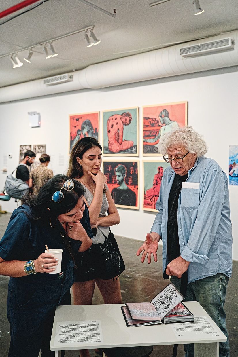 Visitors view and discuss the Palestinian artist Sohail Salem’s war diary on display at Recess Art during the Gaza Biennale in New York, Sept. 11, 2025. The exhibition aims to give a voice to people making creative work about their lives in a war zone. (Shuran Huang/The New York Times)