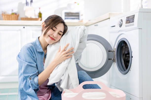 Asian housewife wash clothes happilyat home