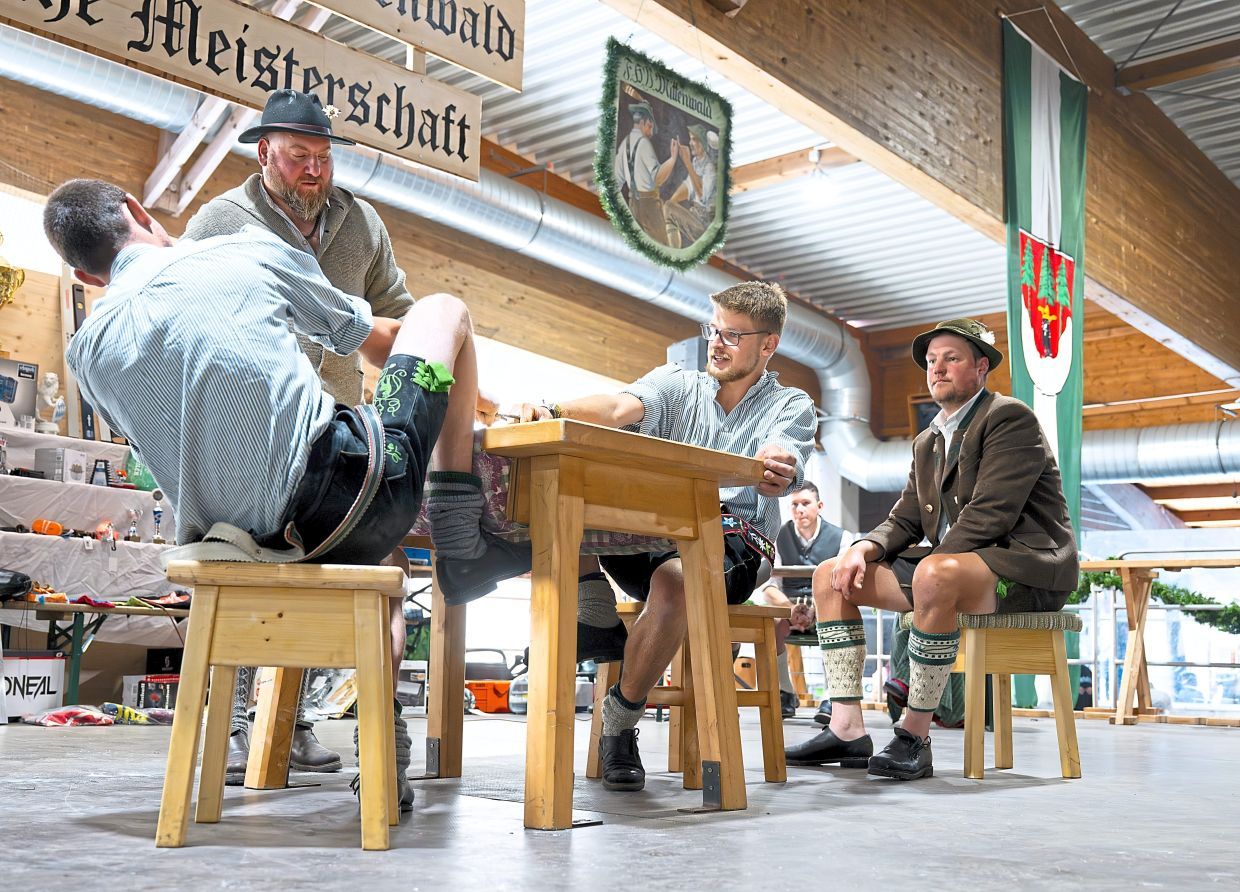 FILED - Participants compete for the Bavarian finger wrestling championship. During the competition, opponents sit opposite each other on stools at a table and try to pull their opponent towards them by their finger. Behind each wrestler sits a catcher. Who can manage to pull the other over to them? Photo: Sven Hoppe/dpa