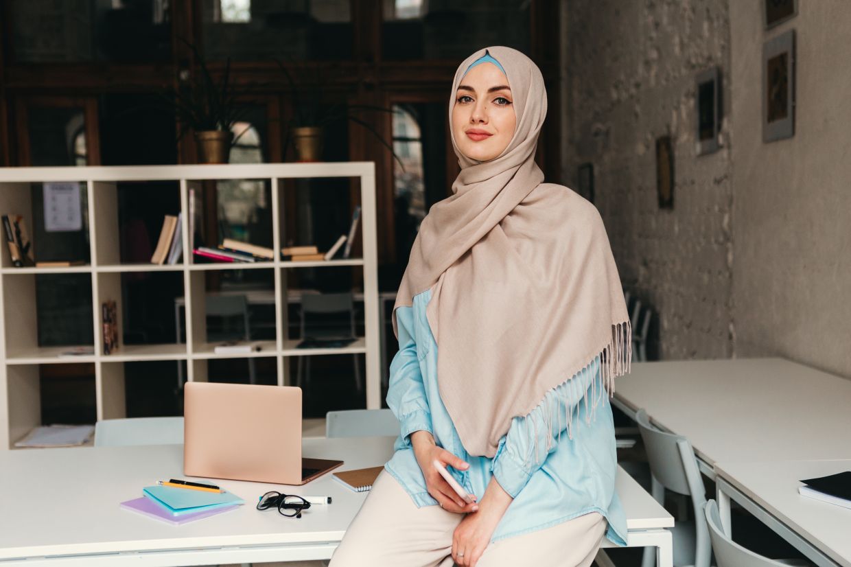 young pretty modern muslim woman in hijab working in office room, education online, remote work freelancer, fashion style