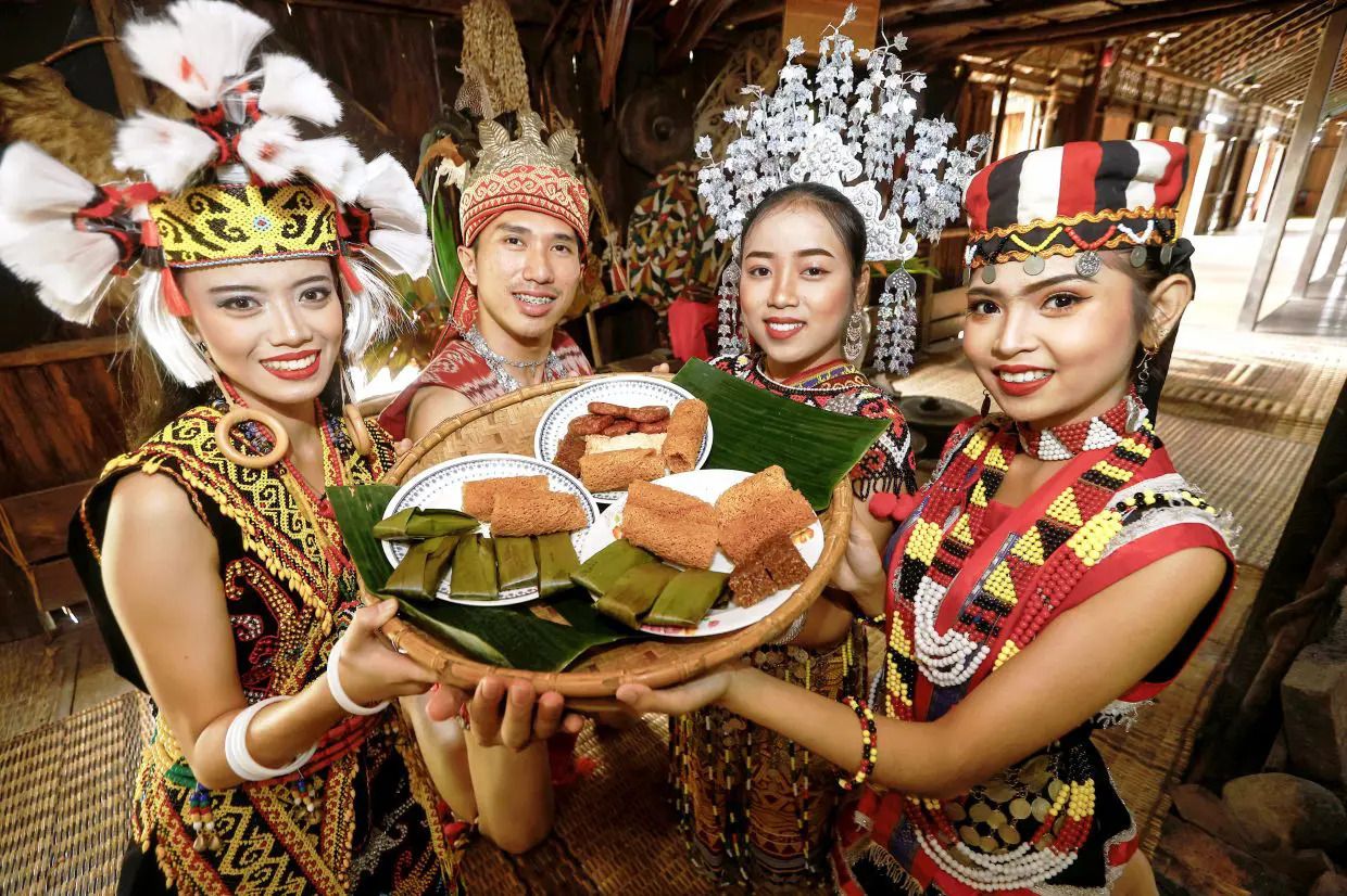 (STAND ALONE PICTURE FOR GAWAI) (From left) Enyssa Christeny Freddy, Mohd Sihabuddin Sa'at, Audreynna Clarissia George and Siti Nur Balqis Marais ready to serve traditional snacks to guests at the Sarawak Cultural Village's Gawai open house. Visitors can enjoy local dishes such as pansoh (chicken cooked in bamboo), kuih jala, lemang and rice wrapped in banana leaf at the Iban longhouse during the open house on June 1-2 in conjunction with the harvest festival celebrated by Sarawak’s Dayak community. — ZULAZHAR SHEBLEE / The Star
