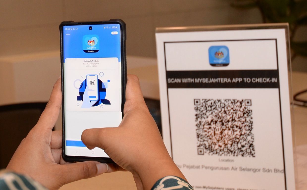 JulianaEdwin scanning the MySejahtera QR code at the Air Selangor headquarters.Ong Soon Hin/ The Star