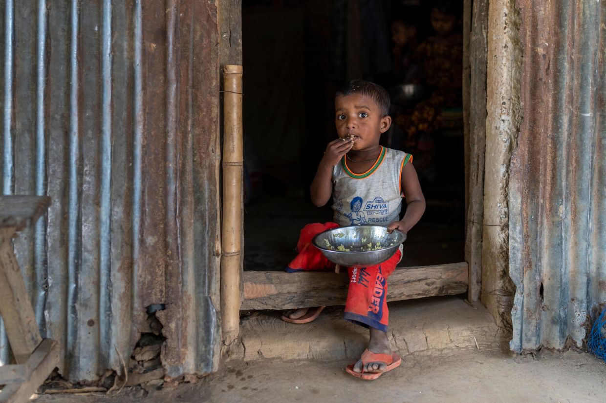 Children eating puffed rice at the doorstep of his uncle Kawsar Miah’s house. He often likes to spend time here. Mahtabpur, Balishjhuri, Tahirpur, Sunamganj, Sylhet. January 03, 2023. UNICEF/Tapash Paul