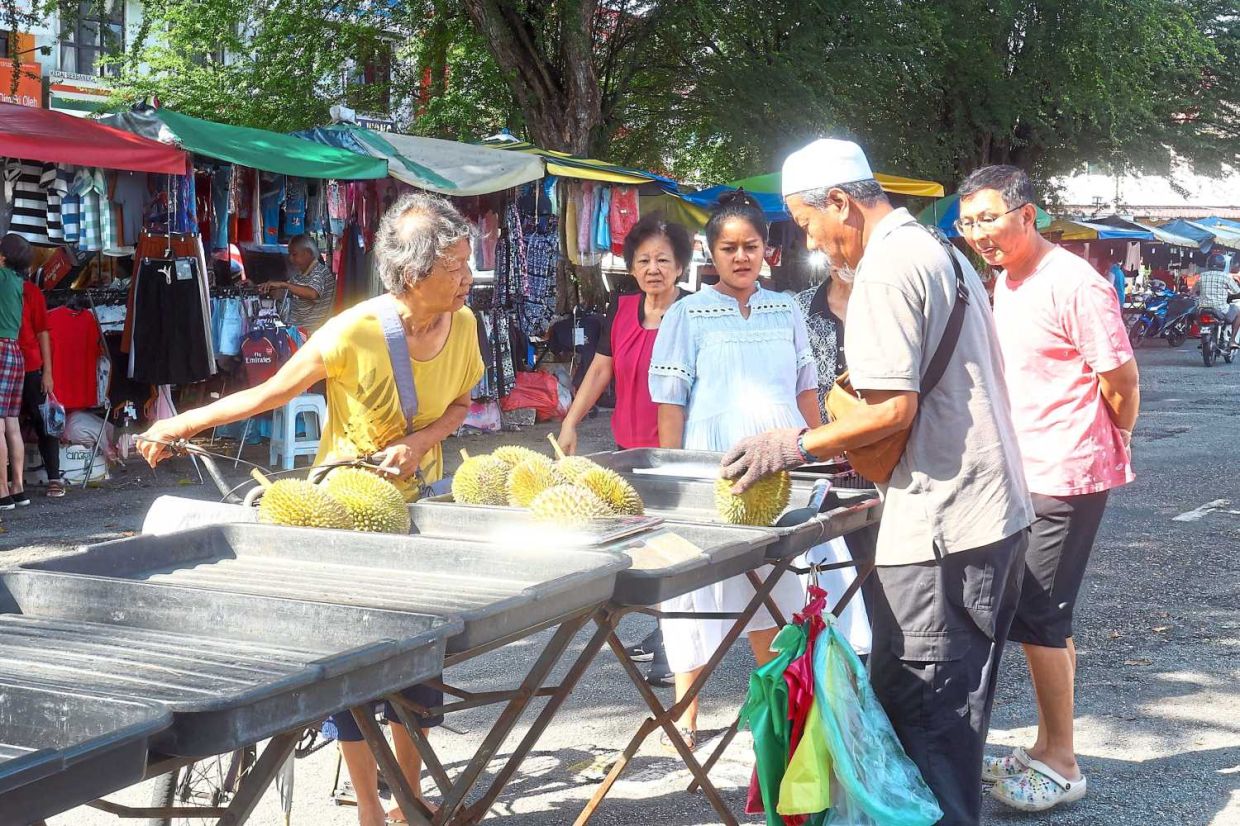 Customers purchasing durians from Mohd Latib Said.